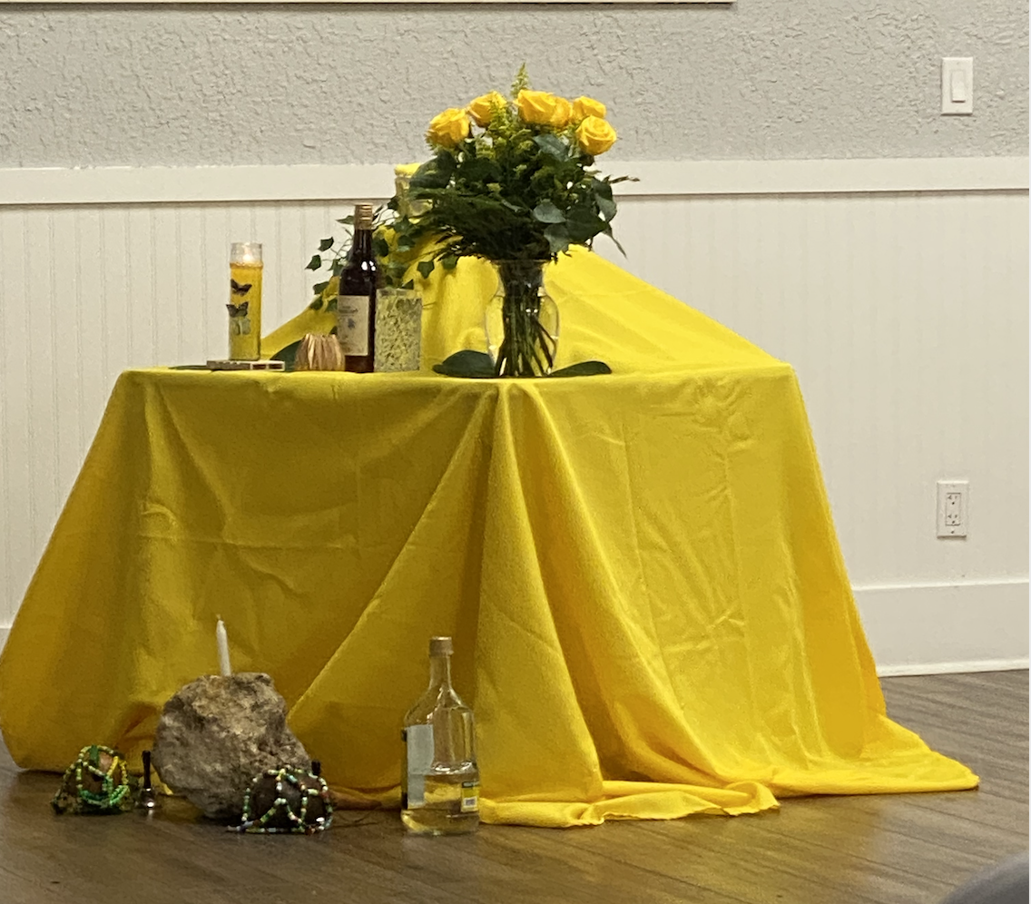 A traditional Haitian Vodou altar adorned with yellow textiles and ceremonial objects